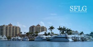 image of boats at a dock in Fort Lauderdale with palms and buildings in background and blue sky