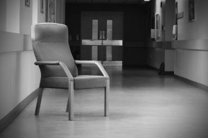 monochrome image of chair in hospital hallway